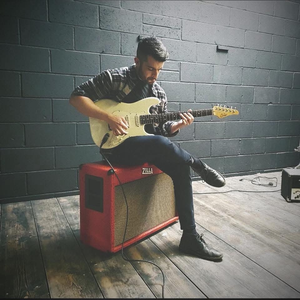 James playing electric guitar on stage